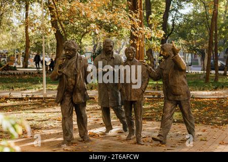 Una statua di bronzo di cinque uomini che parlano l'uno con l'altro e si trovano all'unisono in un parco Foto Stock