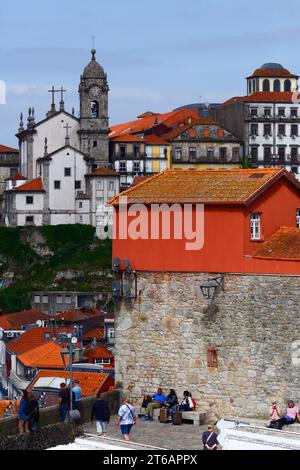 Turisti che visitano il punto panoramico di Miradouro da Rua das Aldas, la chiesa di Nossa Senhora da Vitoria sullo sfondo, il quartiere di Ribeira, Porto / Oporto, Portogallo Foto Stock