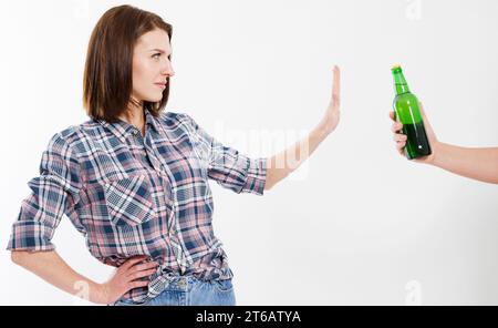 femmina rifiuta una bottiglia di alcol di birra isolata su sfondo bianco. Concetto anti-alcol. Copia immagine isolata dello spazio Foto Stock