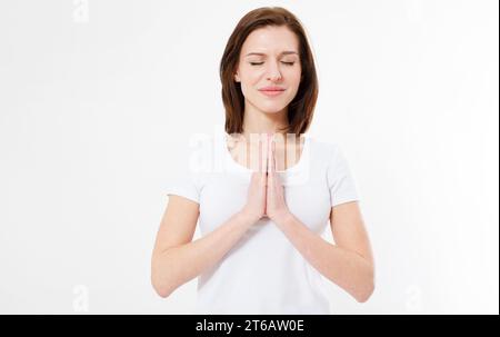 la ragazza con la t-shirt prega con gli occhi chiusi Foto Stock