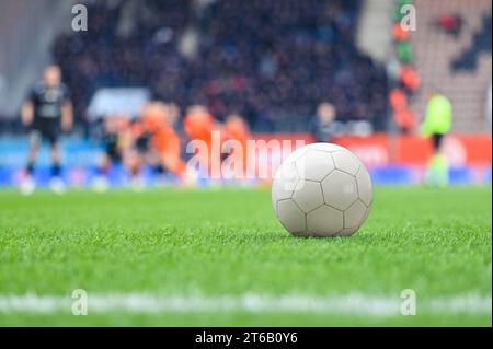 Pallina sul campo di calcio e giocatori sullo sfondo durante la partita allo stadio. Foto Stock