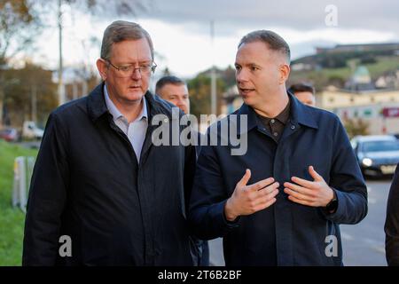 Lord Caine (a sinistra) ascoltando il deputato di Sinn Fein per South Down Chris Hazzard durante una visita alla città colpita dalle inondazioni Co Down, dove diversi negozi del centro cittadino erano completamente sommersi dall'acqua. Data foto: Giovedì 9 novembre 2023. Foto Stock