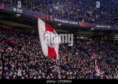 Amsterdam, Paesi Bassi. 9 novembre 2023. AMSTERDAM, PAESI BASSI - 9 NOVEMBRE: Tifosi e tifosi dell'AFC Ajax con una bandiera durante la partita del gruppo B di UEFA Europa League 2023/24 tra l'AFC Ajax e il Brighton & Hove Albion alla Johan Cruyff Arena il 9 novembre 2023 ad Amsterdam, Paesi Bassi. (Foto di Rene Nijhuis/Orange Pictures) credito: Orange Pics BV/Alamy Live News Foto Stock