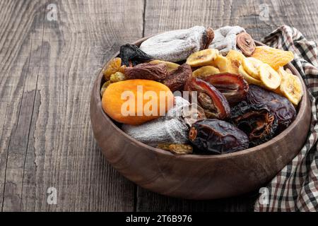 Frutta secca in un recipiente di legno su un tavolo rustico in legno Foto Stock