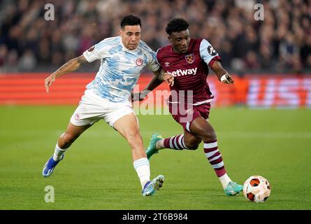 Francisco Ortega (a sinistra) dell'Olympiacos e Mohammed Kudus del West Ham United si battono per il pallone durante la partita di UEFA Europa League Group A allo Stadio di Londra. Data foto: Giovedì 9 novembre 2023. Foto Stock