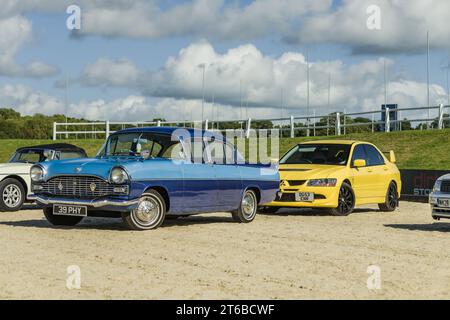 Chester, Cheshire, Inghilterra, 29 settembre 2023. Vauxhall Cresta blu e Mitsubishi EVO VIII giallo in mostra su un'auto d'epoca. Foto Stock