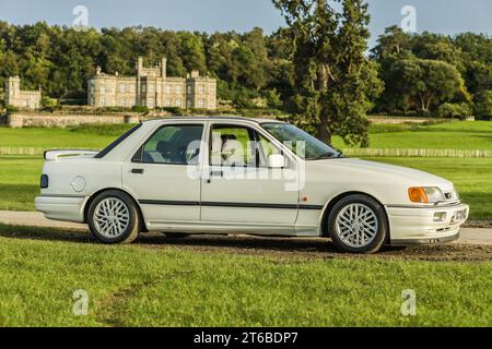 Chester, Cheshire, Inghilterra, 29 settembre 2023. White Ford Sierra RS Cosworth Sapphire con Bolesworth Castle sullo sfondo. Foto Stock