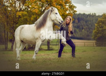 Una giovane donna e il suo cavallo islandese che lavorano e si coccolano insieme, concetto equestre di equitazione naturale Foto Stock