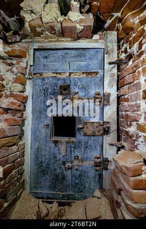 Vecchia porta in una prigione abbandonata in rovina. Foto Stock