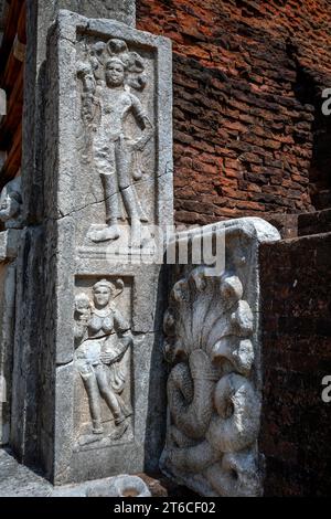 Figure scolpite in pietra sedute alla base del Jetawanaramaya Dagoba nell'antica città di Anuradhapura in Sri Lanka. Foto Stock