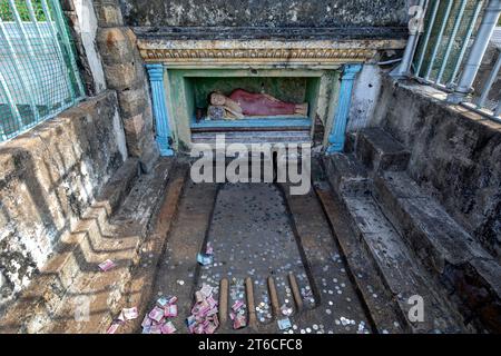 Un recinto contenente una statua di Buddha reclinata situata di fronte a un'impronta di pietra scolpita in cima all'Isurumuni Raja Maha Viharaya ad Anuradhapura Foto Stock