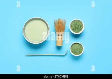 Composizione con tè matcha fresco, polvere e accessori su sfondo colorato Foto Stock