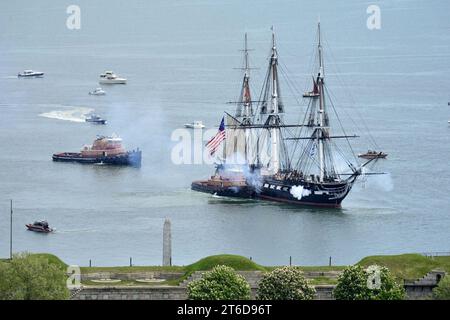 La USS Constitution spara i suoi cannoni mentre viene rimorchiata attraverso il porto di Boston. (51200023793) Foto Stock