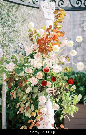 Colonna di un gazebo intrecciata con fiori luminosi nel giardino Foto Stock