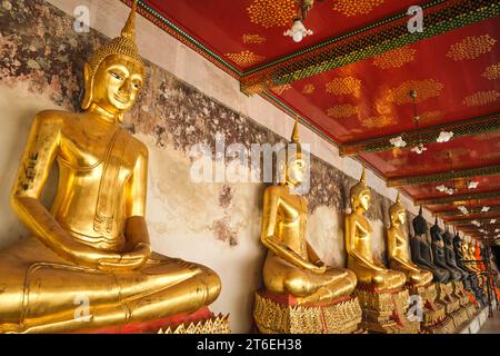 Una fila infinita di statue di Buddha seduto in oro fiancheggiano un portico che circonda il tempio. A Wat Suthat Thepwararam Ratchaworamahawihan a Bangkok, Tha Foto Stock
