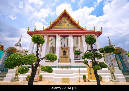 Vista esterna dell'incombente tempio con alte colonne bianche. A Phra Ubosot Wat Suthat a Bangkok, Thailandia. Foto Stock