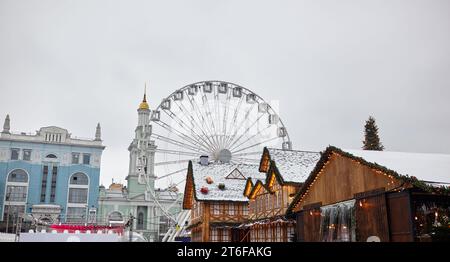 Il tetto della Casa decorato per il Natale nella città europea. Facciata di casa per le vacanze natalizie sullo sfondo di una ruota panoramica Foto Stock