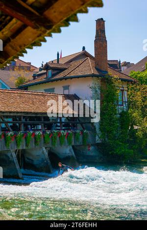 Surfista sul fiume Aare nella città di Thun dal ponte Untere Schleuse in una soleggiata giornata estiva, Oberland Bernese, Cantone di Berna, Svizzera Foto Stock