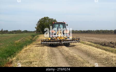 agricoltore sul trattore che lavora su un campo Foto Stock