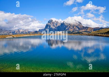 Plattkofel e Langkofel innevati, lago con pesci, riflessi, Dolomiti, Alpe di Siusi, neve, nuvole e cielo blu, Castelrotto, alto Adige Foto Stock