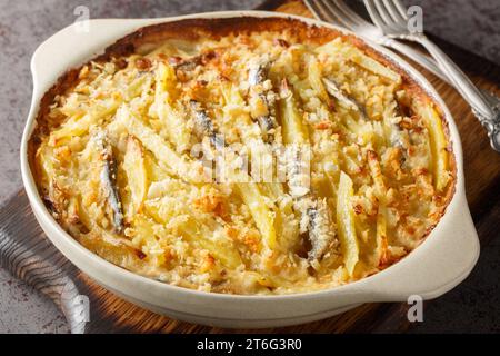 Il frestelse di Jansson o Janssons Temptation è un piatto svedese al gratin a base di patate, cipolla e spratti primo piano sul piatto da forno sul tavolo Foto Stock