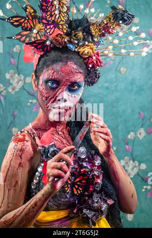 Primo piano della donna vestita in costume per la notte di Halloween. Atmosfera coperta da fumo sottile. Creativo, artistico, concetto di Halloween. Foto Stock