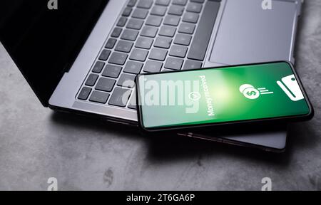 Smartphone posizionato sul portatile con la notifica di denaro ricevuta sullo schermo. Messa a fuoco selettiva. Concetto di transazioni finanziarie con dispositivi mobili. Foto Stock