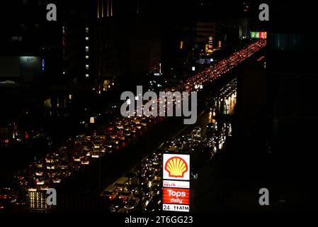 Vista dall'alto del traffico di auto e veicoli su Sathorn Road, Silom e Sathon District, centro di Bangkok, Thailandia, Sud Est Asiatico subito dopo le 18.00. I conducenti di veicoli faticano a progredire nel traffico intenso nelle ore di punta. (Editori: Mi scuso che l'ora della fotocamera sia ancora a Londra, perché avevo dimenticato di aggiornarla al mio arrivo a Bangkok) Foto Stock