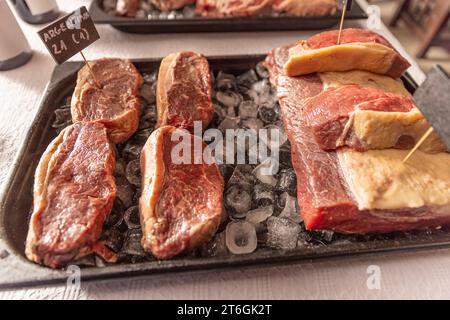 Vassoio di carne cruda, tagliato a pezzi grandi e posto su un letto di ghiaccio Foto Stock