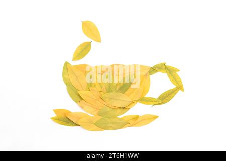 una tazza fatta con foglie gialle su una superficie bianca, minimalista, isolata su sfondo bianco Foto Stock