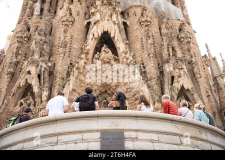 I turisti guardano e scattano foto della Sagrada Familia a Barcellona Foto Stock