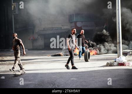 Jenin, Palestina. 9 novembre 2023. I giovani palestinesi bruciano le gomme durante un sanguinoso raid al campo profughi di Jenin. Le forze israeliane hanno fatto irruzione nel campo profughi di Jenin ed sono entrate con le loro forze all'interno, il che ha portato a uno scambio di fuoco tra combattenti armati della resistenza palestinese e le forze (uno scontro armato). I giovani dimostrarono, bruciarono pneumatici ovunque, e il raid continuò per più di 12 ore. 14 palestinesi sono stati uccisi dalle forze israeliane e molti sono rimasti feriti. (Immagine di credito: © Nasser Ishtayeh/SOPA Images via ZUMA Press Wire) SOLO USO EDITORIALE! Non per USO commerciale! Foto Stock