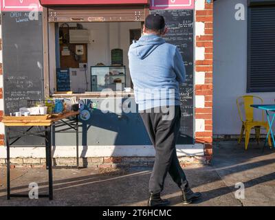 Persona che aspetta cibo e bevande al Café on the Beach, Marine Parade Hythe, cibo e bevande sul mare Foto Stock