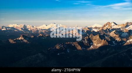 Le nevose Alpi vallesi brillano alla prima luce del mattino in una soleggiata giornata estiva. Monte Rosa, Mischabel, Cervino, Weisshorn. Svizzera, Europa Foto Stock