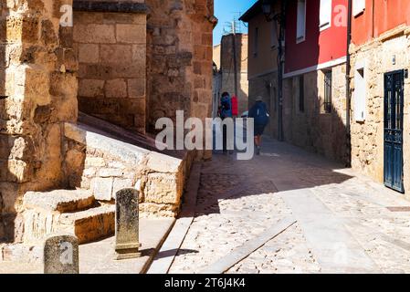 Due pellegrini con zaini sulla via di San Giacomo, Camino de Santiago, attraverso il villaggio di Castrojeriz, provincia di Burgos, Castiglia-Leon, Spagna Foto Stock