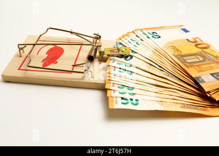 Banconote in euro in un mousetrap isolato su fondo bianco, concetto intrappolato dai debiti Foto Stock