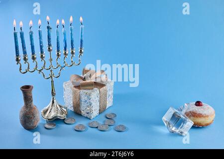 Festa ebraica Hanukkah con menorah, tradizionale candelabro, ciambelle e dreidel, top rotante. Foto Stock