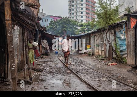 Un uomo si bilancia su una ferrovia di una ferrovia, Tejgaon Slum area, Dacca, Bangladesh Foto Stock