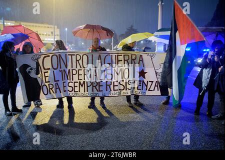 Roma, Italia. 10 novembre 2023. Le persone con gli ombrelli sotto la pioggia tengono lo striscione con le parole "contro la guerra e l'imperialismo ora e sempre resistenza” accanto alla bandiera palestinese durante la manifestazione pro-palestinese a Roma. Poche centinaia di persone hanno partecipato alla manifestazione organizzata dal movimento studentesco palestinese per chiedere un immediato cessate il fuoco e l'apertura di corridoi umanitari. Dopo l'occupazione dell'Università della Sapienza e il raid nella sede del Parlamento europeo a Roma, la pioggia non ha fermato i cittadini italiani e palestinesi che denunciano la AT Foto Stock