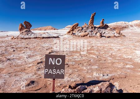 Formazioni saline di Tres Marias nella Valle de la Luna nel deserto di Atacama, Cile. Il cartello recita "No Pasar" - avverte i turisti di non entrare nella zona. Foto Stock