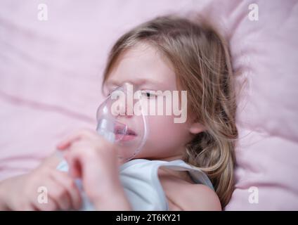 Bambina che fa l'inalazione della droga ormonale usando il nebulizzatore Foto Stock