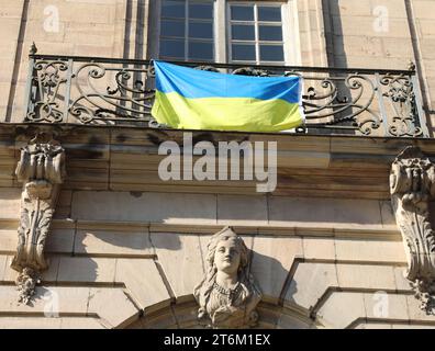 Bandiera Ucraina con colori giallo e blu appesa alla ringhiera di un edificio in Europa Foto Stock