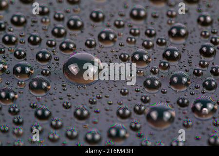 gocce d'acqua sulla superficie dello schermo del cellulare, primo piano con messa a fuoco selettiva e sfocatura Foto Stock