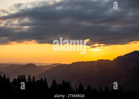 tramonta sopra la montagna nelle alpi tedesche con il sole che splende leggermente tra le nuvole Foto Stock