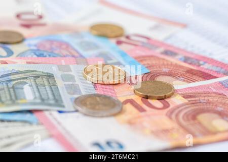 Molte banconote e monete in euro impilate l'una sull'altra. Foto Stock
