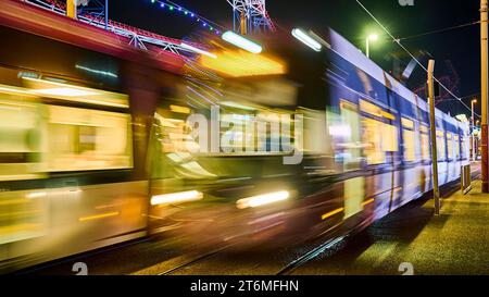 Due tram blackpool passano di notte l'uno accanto all'altro Foto Stock