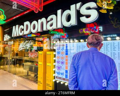 Shanghai, Cina, quartiere degli affari, Senior Man from Behind, Reading Menu Sign, di fronte al McDonald's Fast Food Restaurant, GOME (Changing Branch) City Center, china Capitalism Foto Stock
