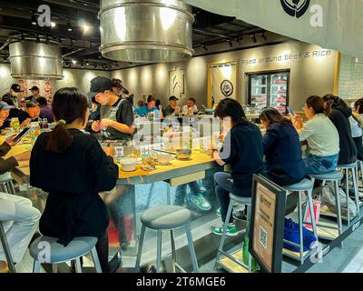 Shanghai, Cina, vedute interne dei supermercati cinesi, del "Jiuguang Department Store", affollano le persone al bar nei ristoranti giapponesi, condividendo cibo e piatti in un ristorante contemporaneo Foto Stock