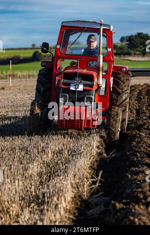 East Lothian, Scozia, Regno Unito, 11 novembre 2023. Partita dell'Associazione aratura East Lothian: L'evento annuale si svolge quest'anno presso l'East Fenton Farm, con i partecipanti a una varietà di trattori d'epoca che arano la loro zona di solchi giudicati in base a una varietà di fattori, tra cui rettilineità, regolarità, profondità e paglia limpida in una fredda giornata di sole. Crediti: Sally Anderson/Alamy Live News Foto Stock