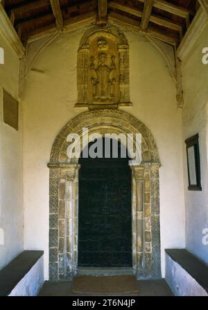 La porta sud decorata in stile normanno e la nicchia a testa semicircolare della chiesa di St Mary; Haddiscoe, Norfolk, Inghilterra, Regno Unito, vista dal portico C15th. Foto Stock